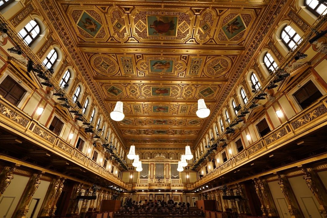 Ornate historic concert hall with balconies, chandeliers, and pipe organ