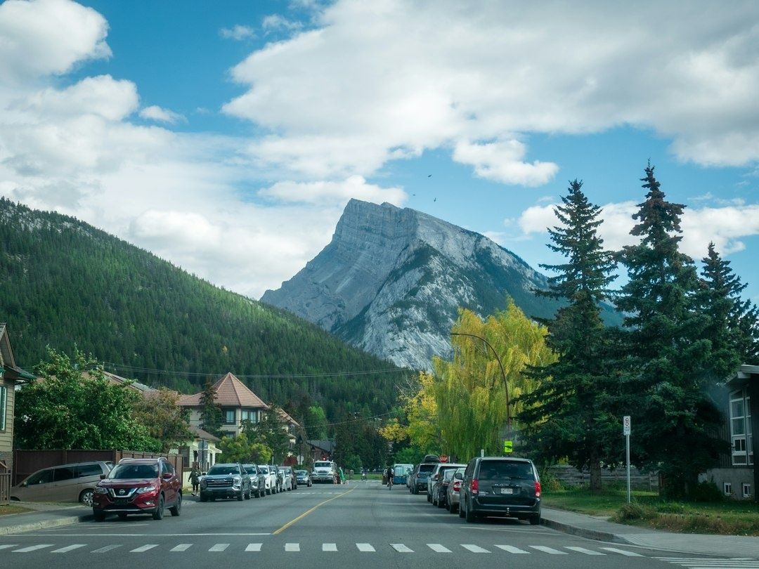 Autumn mountain town street beneath a dramatic rocky peak