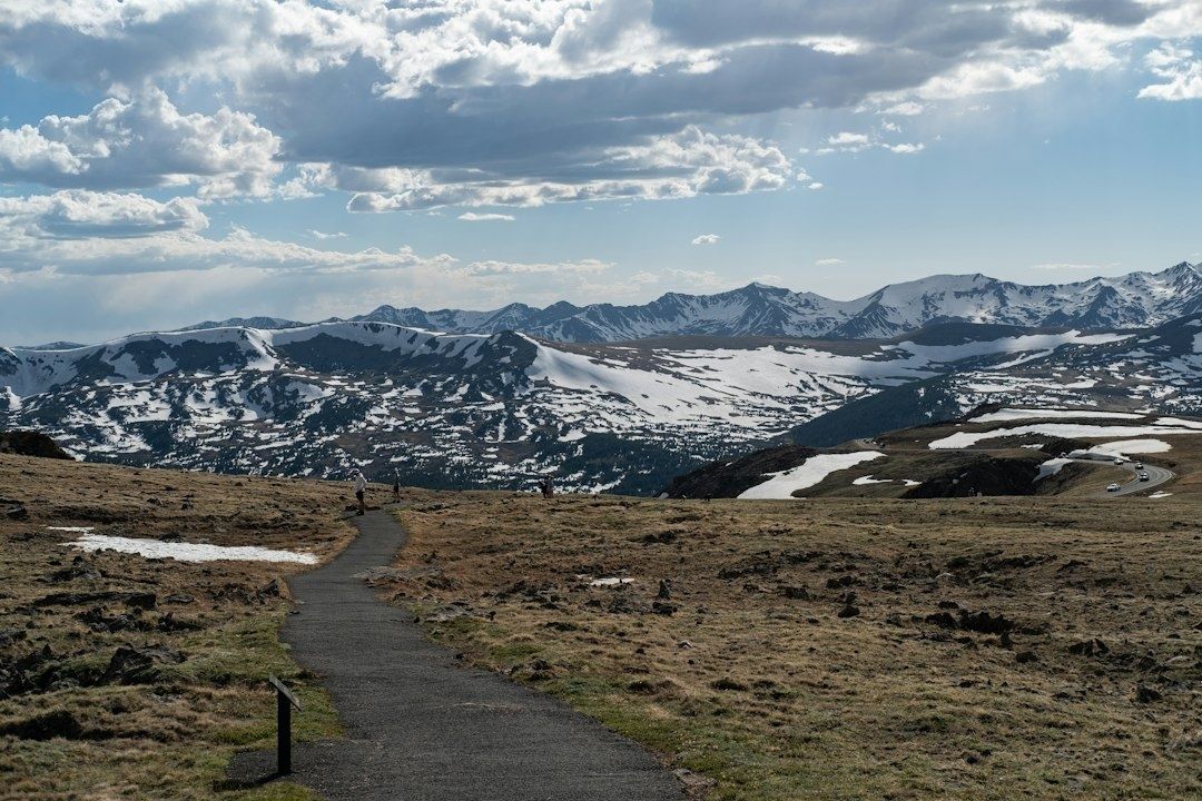 Quiet paved trail across a snowy mountain landscape in early spring
